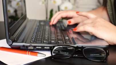 person typing on laptop glasses