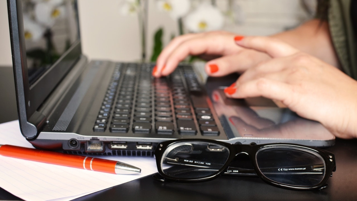 person typing on laptop glasses